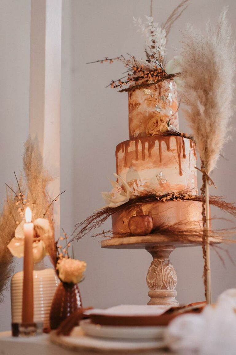 Dreistöckiger Drip Cake in Terrakotta und Dekoration aus Granatäpfeln