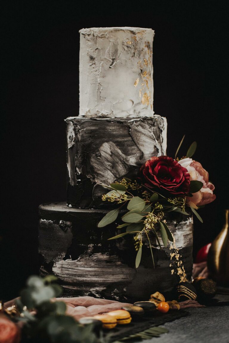 Dreistöckige eingestrichene Hochzeitstorte in weiß und schwarz, verziert mit dunkelroten Pfingstrosen