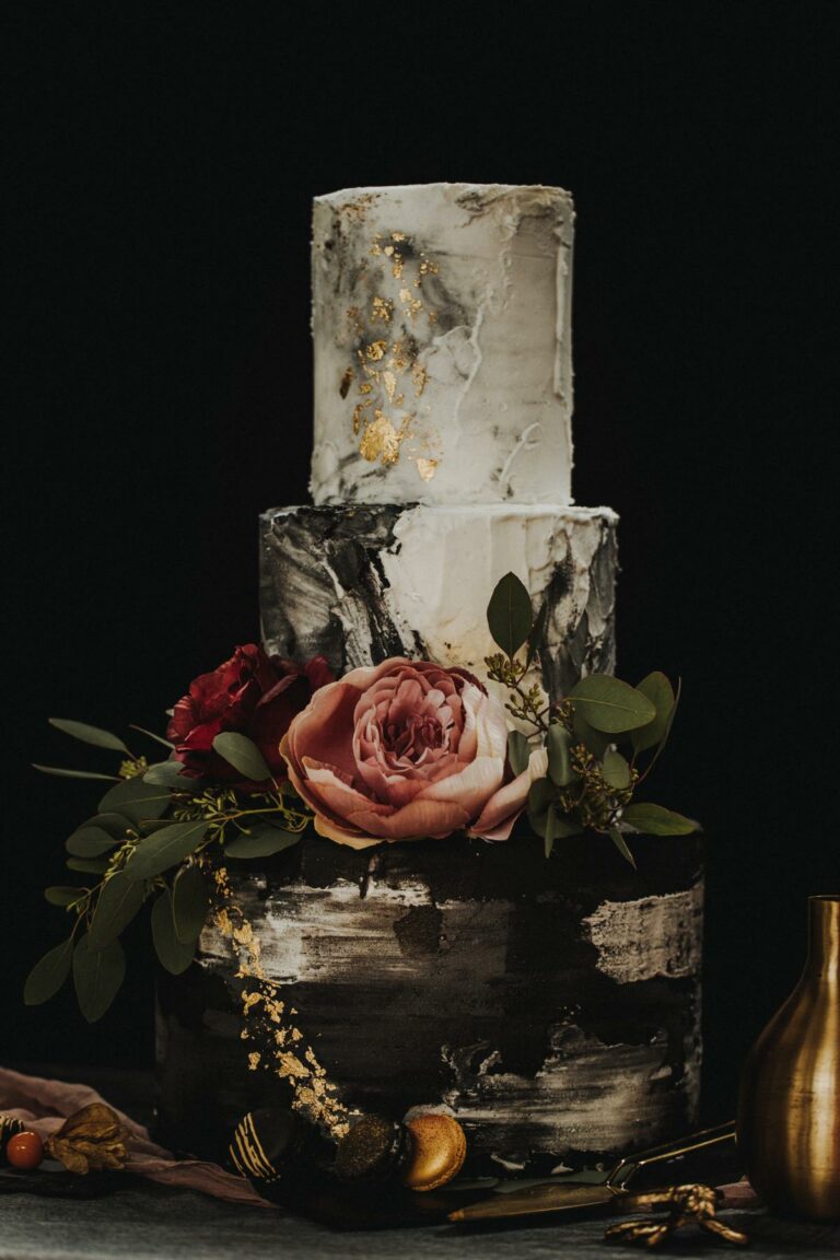 Dreistöckige eingestrichene Hochzeitstorte in weiß und schwarz, verziert mit dunkelroten Pfingstrosen