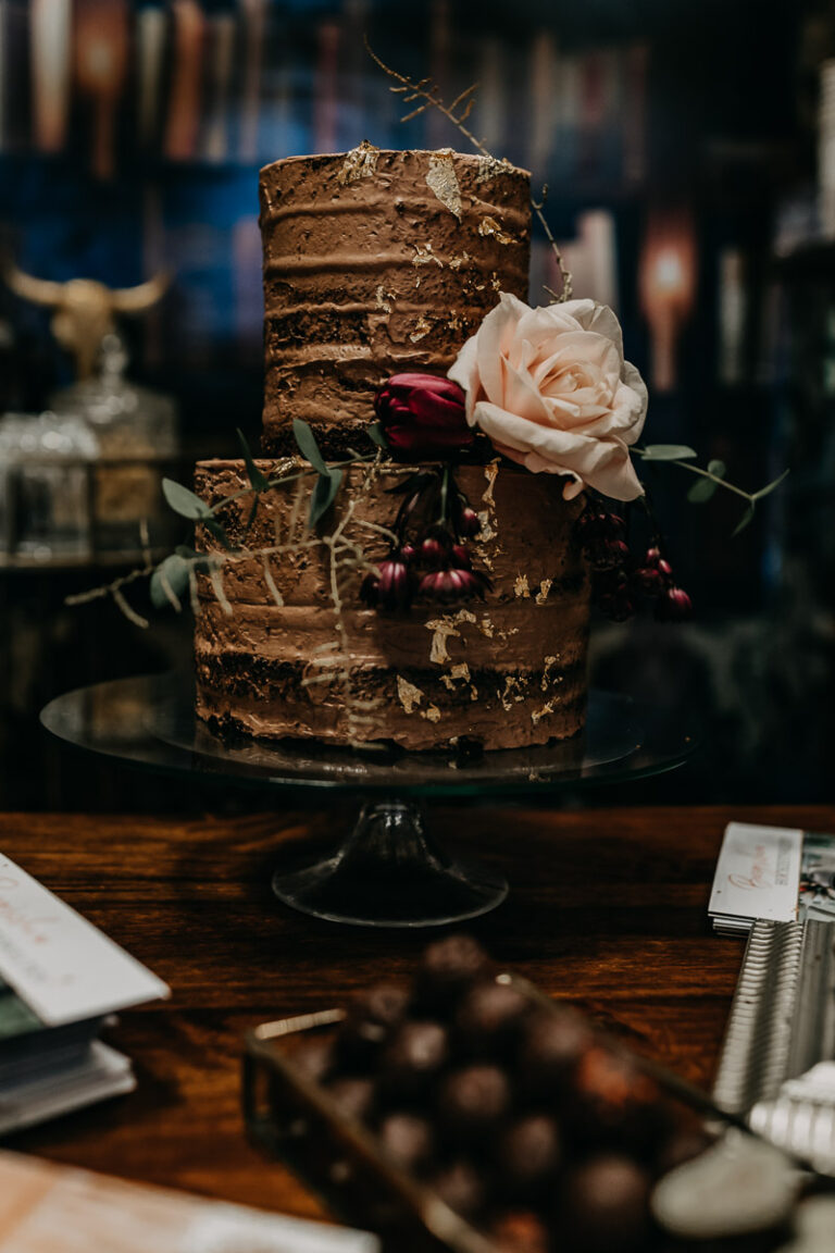 Seminaked Cake aus dunkler Schokolade mit dunklen Böden, verziert mit Blattgold und Eukalyptus